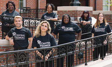 group of diverse STRIVE students on outside lawn of Overcash Center on Central Campus