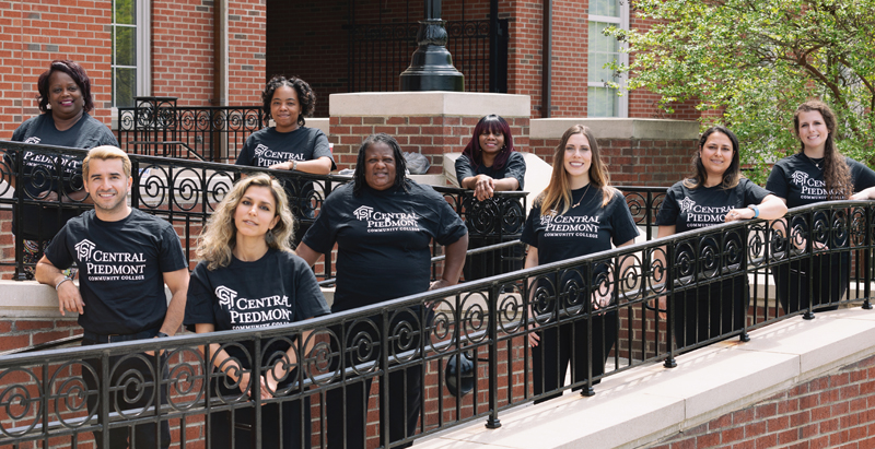 group of diverse STRIVE students on outside lawn of Overcash Center on Central Campus