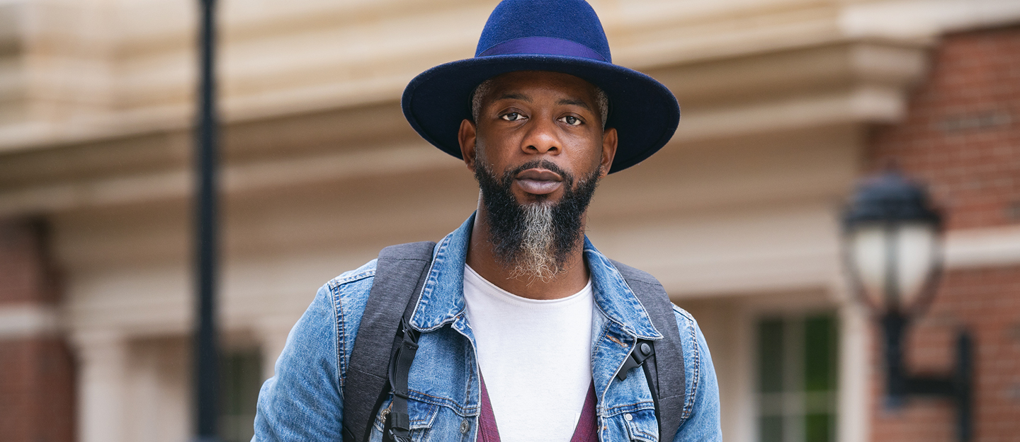 adult student on campus wearing a hat