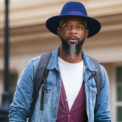 adult student on campus wearing a hat