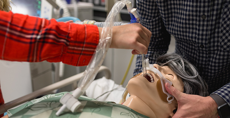 Central Piedmont respiratory therapy students practicing inserting tube into practice dummy