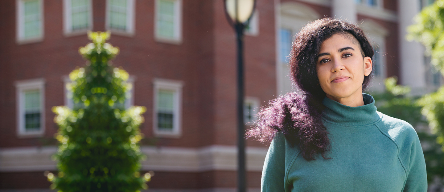 diverse student standing in front of building facing camera