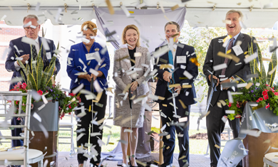 College leadership cutting ribbon with confetti in the air