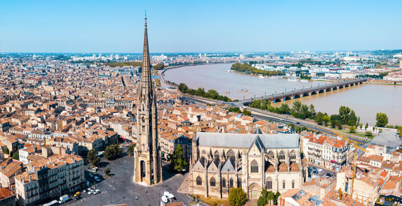 overhead of Bordeaux, France with Basilica of St. Michael, its separate bell tower, and the Garonne river