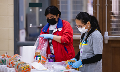 Two students making sandwiches at Spread the Love Event