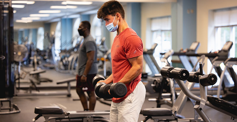 students lifting free weights in a Central Campus fitness center