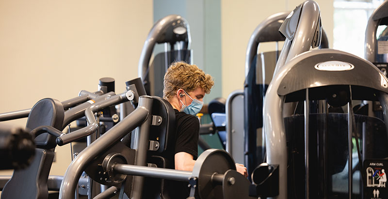 student using weight machine in a Central Piedmont fitness center