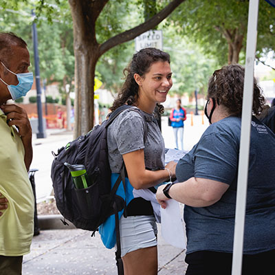 Central Piedmont student engagement staff member helping a smiling student on Central Campus