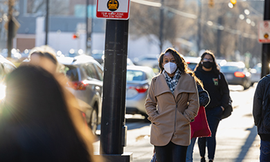 Female student walking down sidewalk on campus