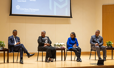 Four panelists on Tate Hall stage