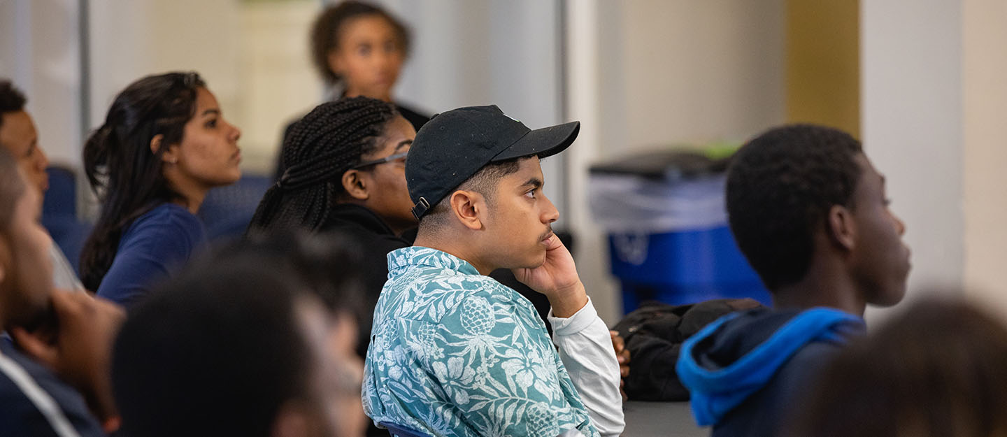 group of diverse students listening in a classroom