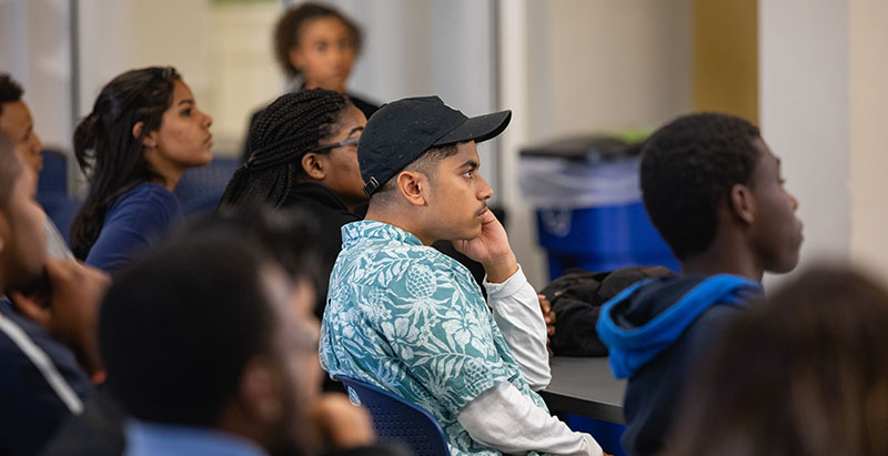 group of diverse students listening in a classroom