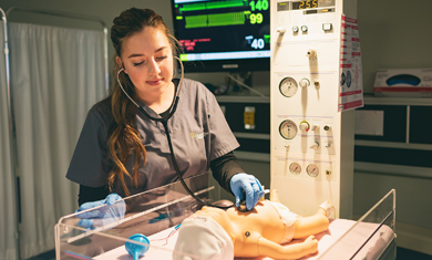 female nursing student working on baby simulator machine