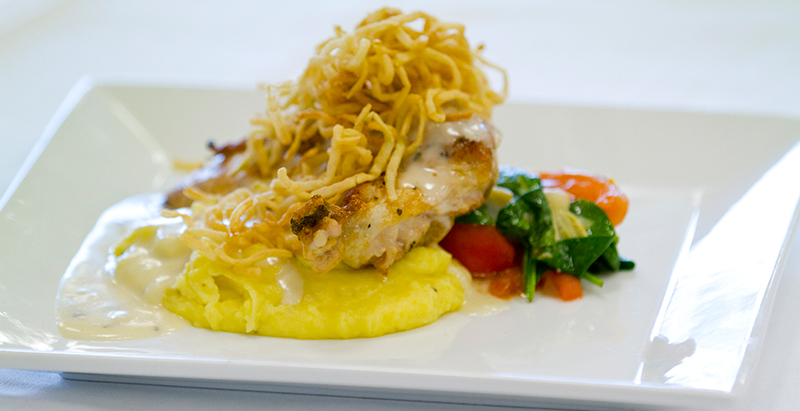 chicken, crunchy noodle, and vegetable dish plated at Greenway restaurant