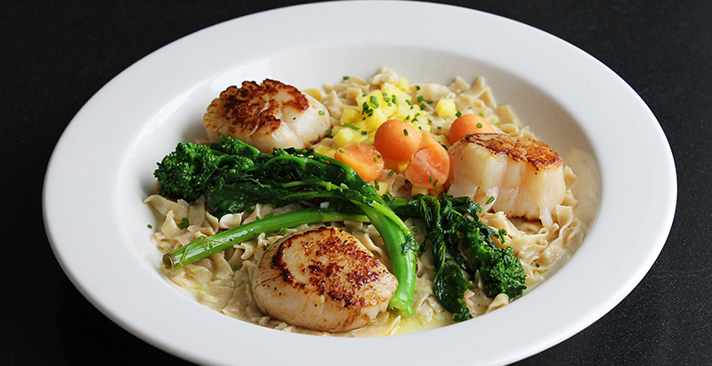 scallops, grain, and vegetable dish plated at Greenway restuarant