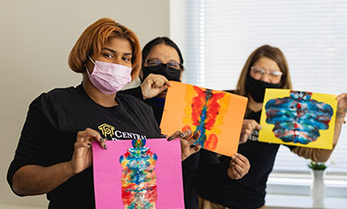 ECE students holding artwork