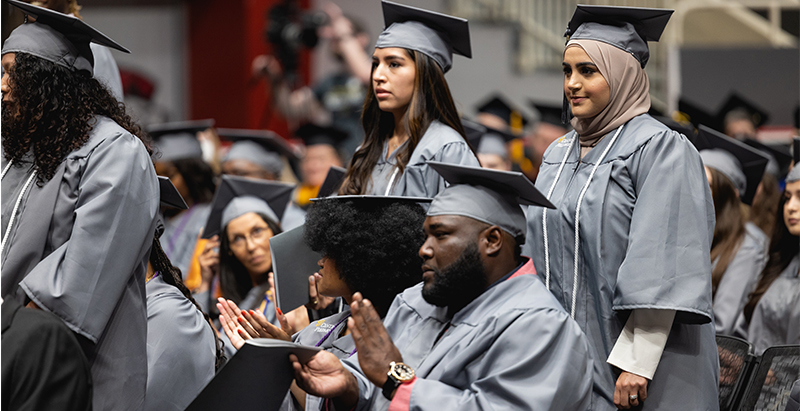 diverse group of students in cap and gown at graduation