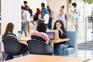 Central Piedmont students sitting at a table using laptop computers