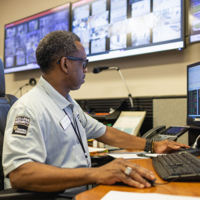 Central Piedmont college security diverse staff member at desk looking at security monitors