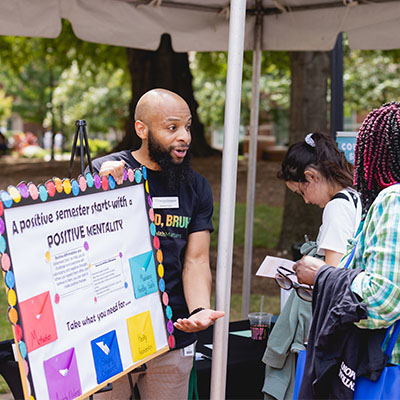 diverse counseling staff member talking with students at Parr Center event outside