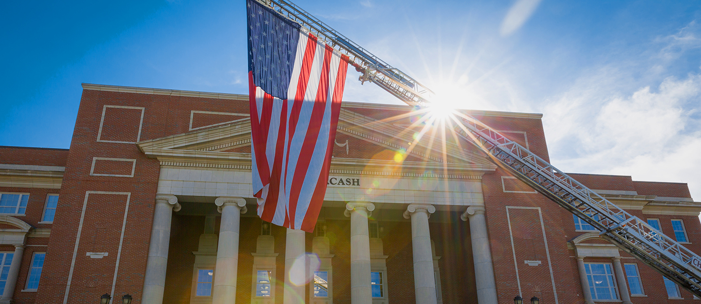 The American Flag hanging in front of the Overcash Building on Central Campus