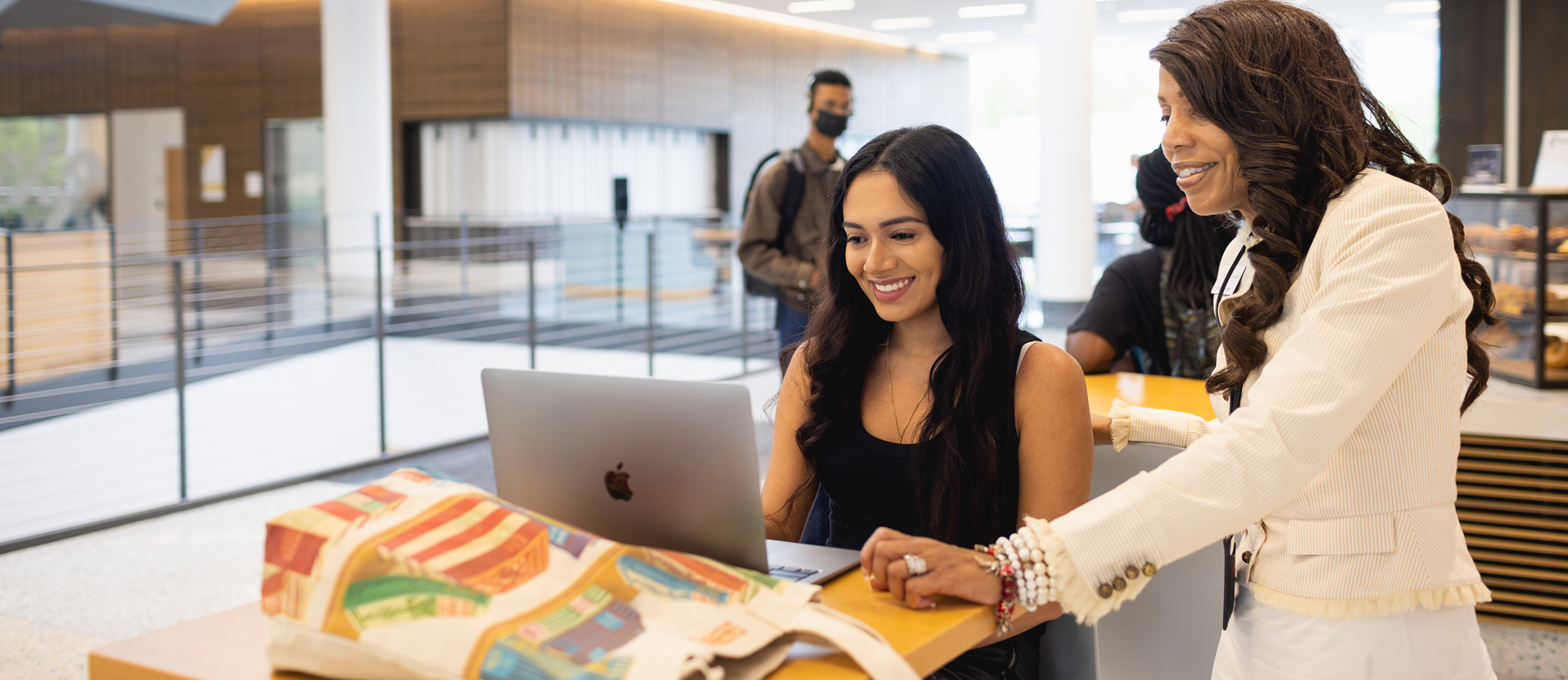 A student works on laptop in the Parr Center with assistance from a staff member