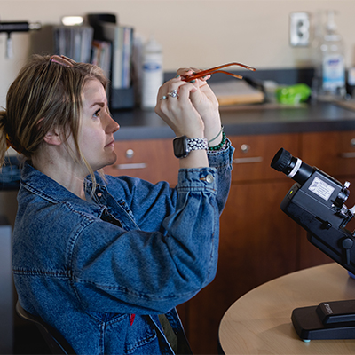 Ophthalmic student examining eyeglasses