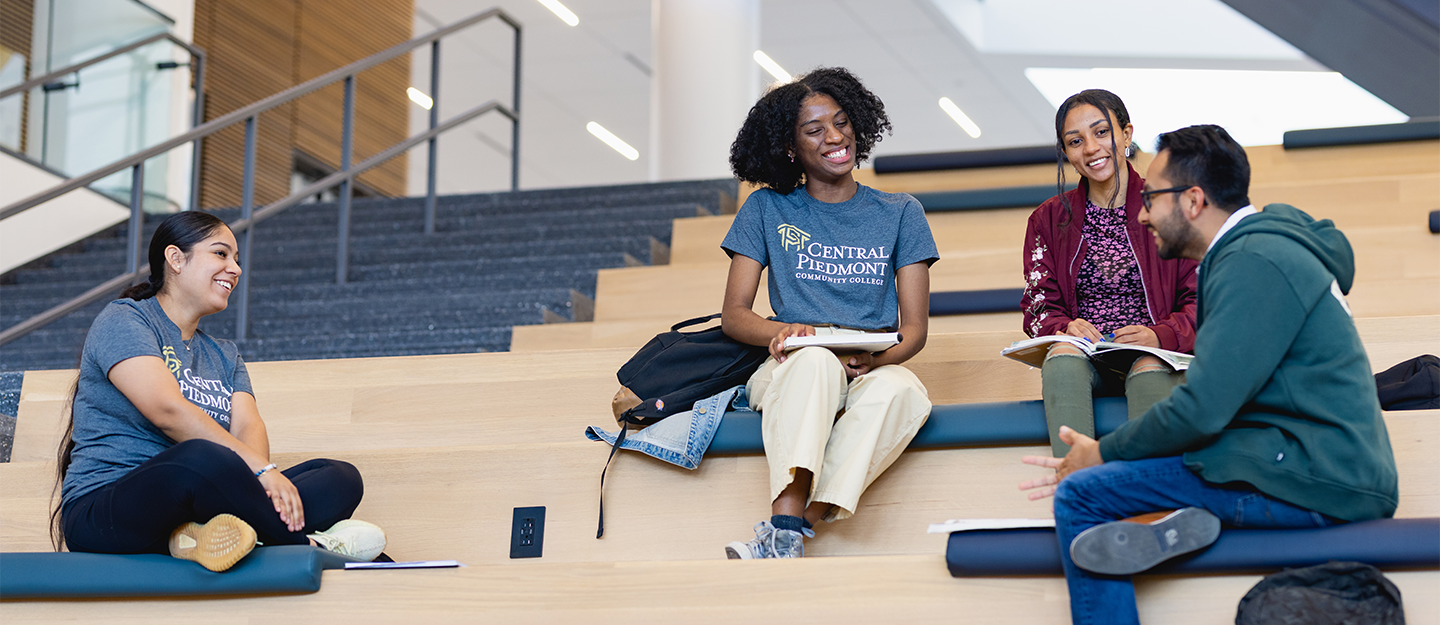 Student ambassadors sitting on the  steps inside the Parr Center smiling 