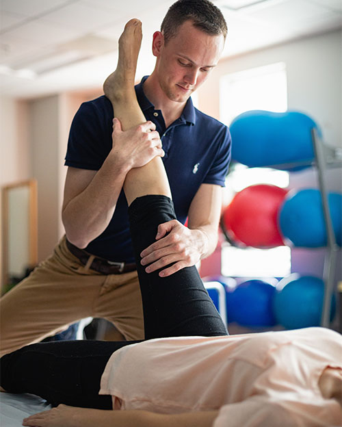 A student doing physical therapy on a patient