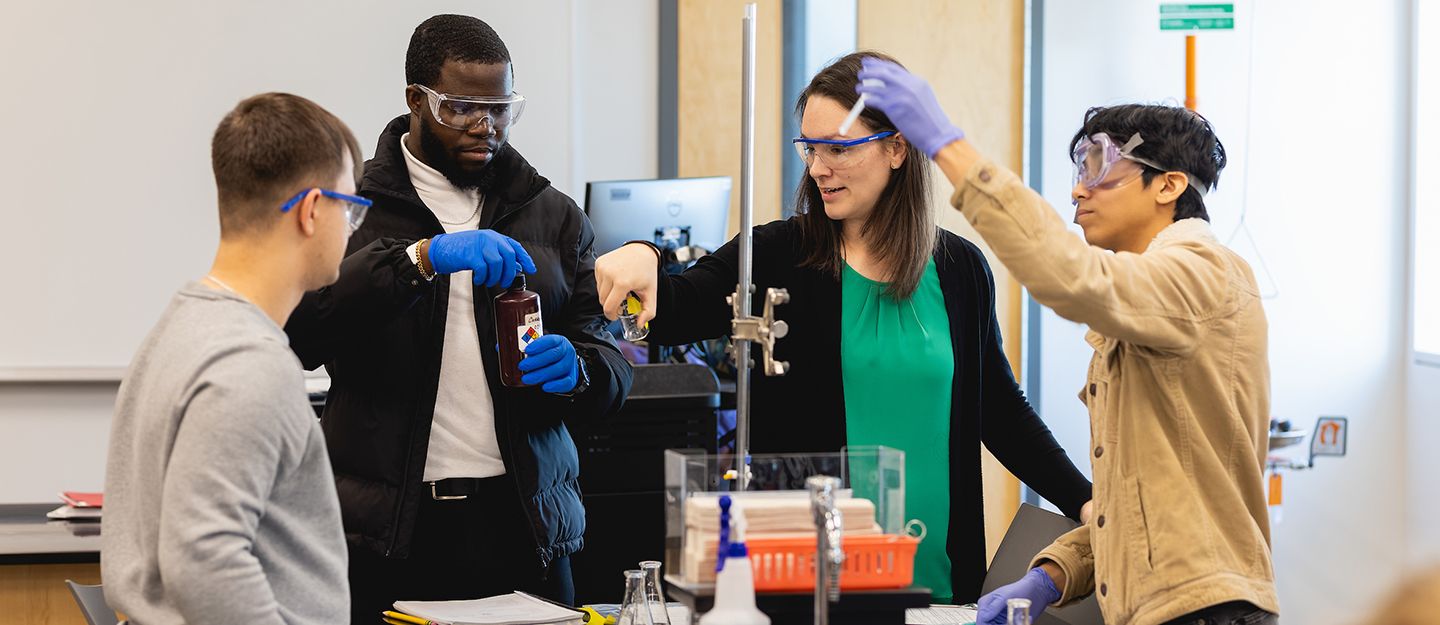 chemistry students conducting and experiment with the instructor