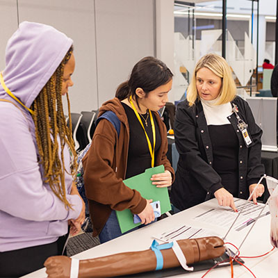 Two high school students in a health lab with an instructor