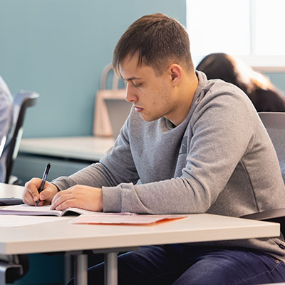 A Central Piedmont student taking notes in a classroom