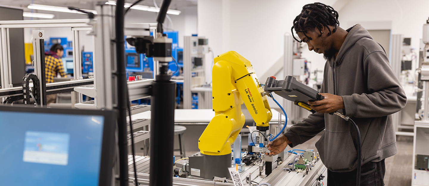 mechatronics student standing in front of equipment