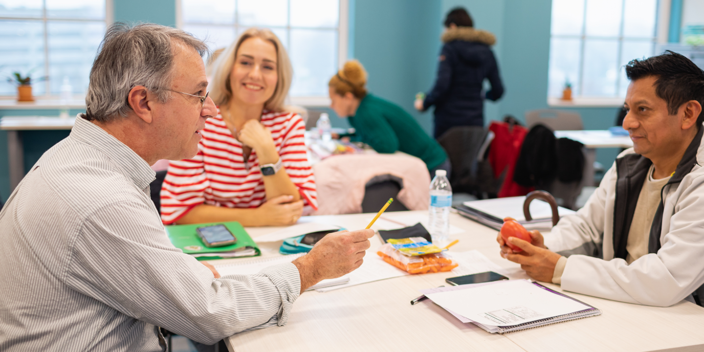 Diverse students sitting at a table working on an assignment 