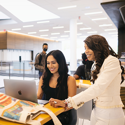 Counselor helping student navigate on the computer 