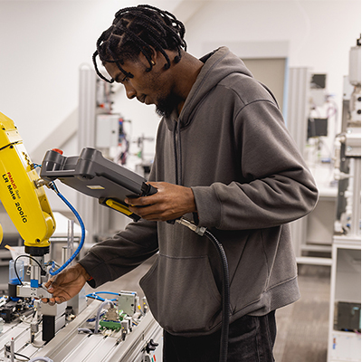 mechatronics student standing in front of equipment