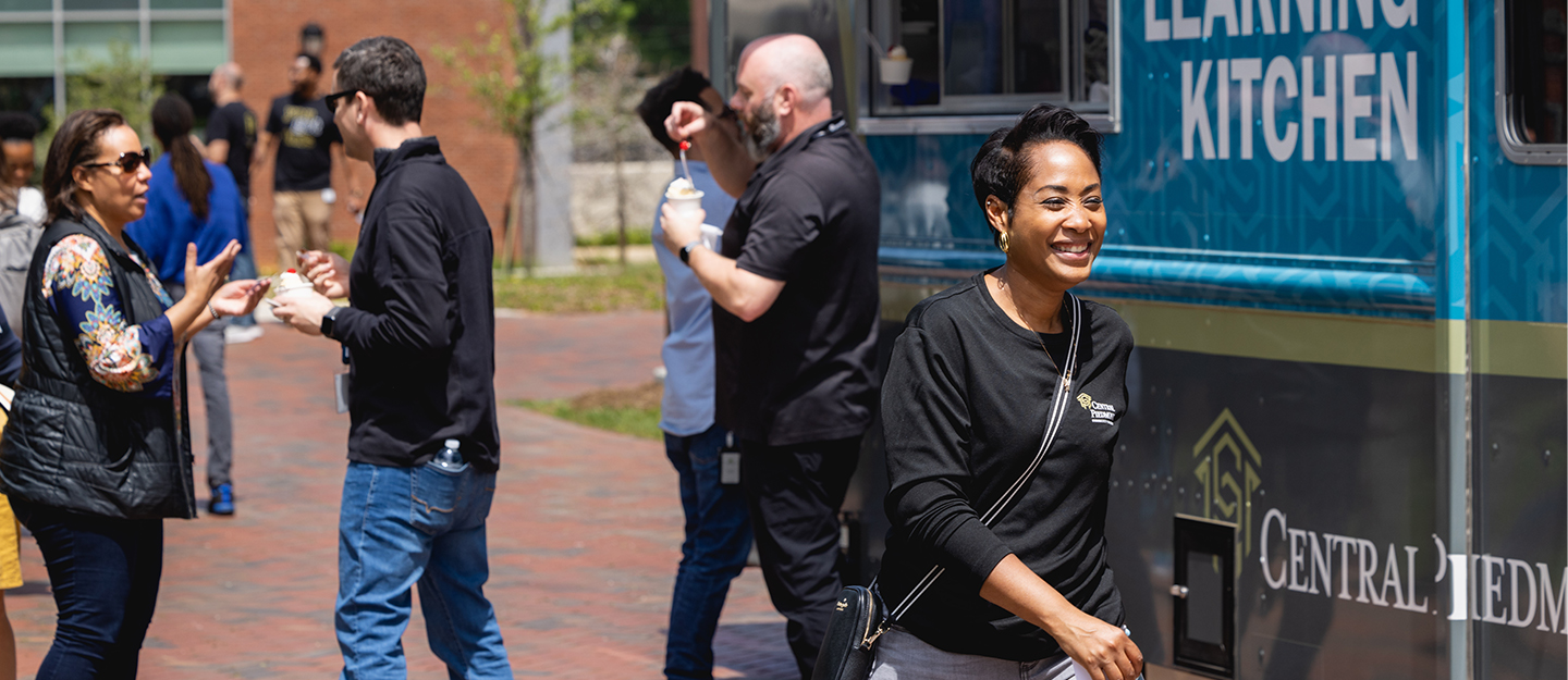 Central Piedmont employees standing in front of food truck at spring event