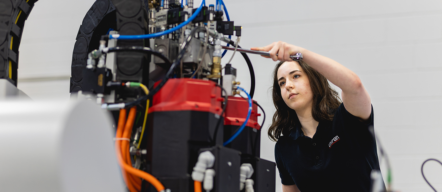 Mechatronics student standing in front of equipment