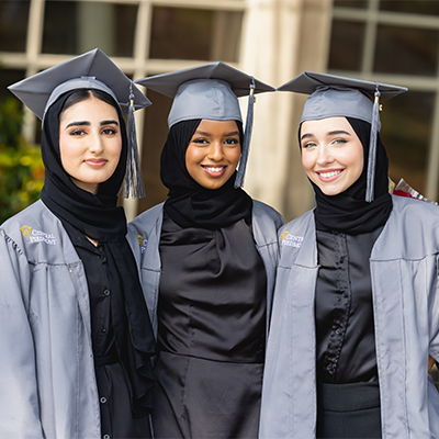 Three students in cap and gown 