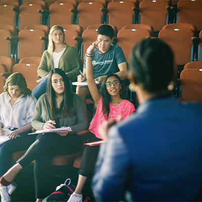 Group in a study hall with one with hand raised 