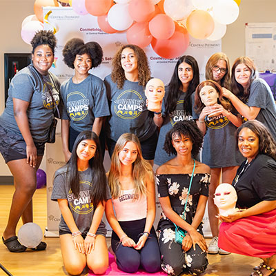 summer camp students in a group looking into camera with balloons behind them
