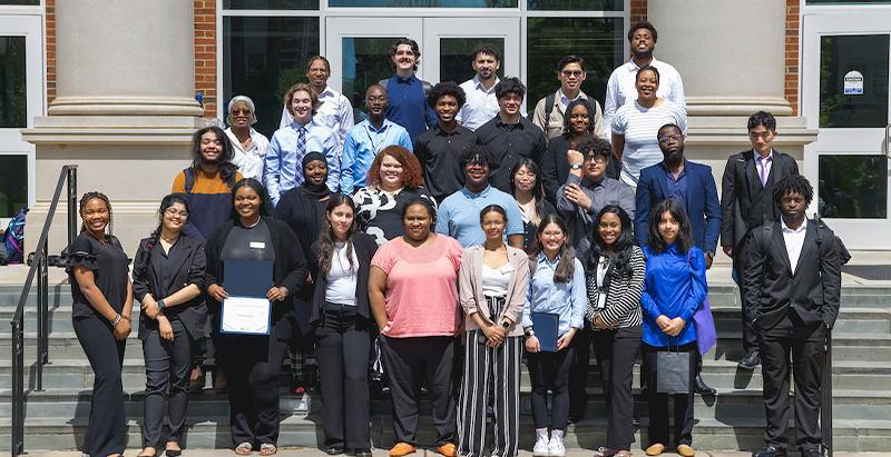 Group of students standing for a photo opportunity on stairs 