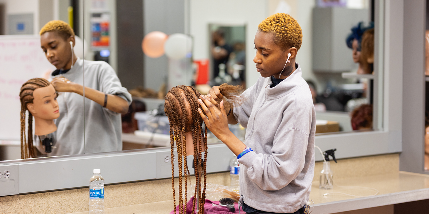 Manikin is getting hair braided 