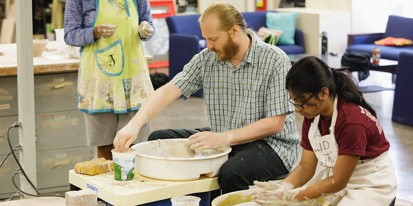 Teaching a person to use a pottery wheel 