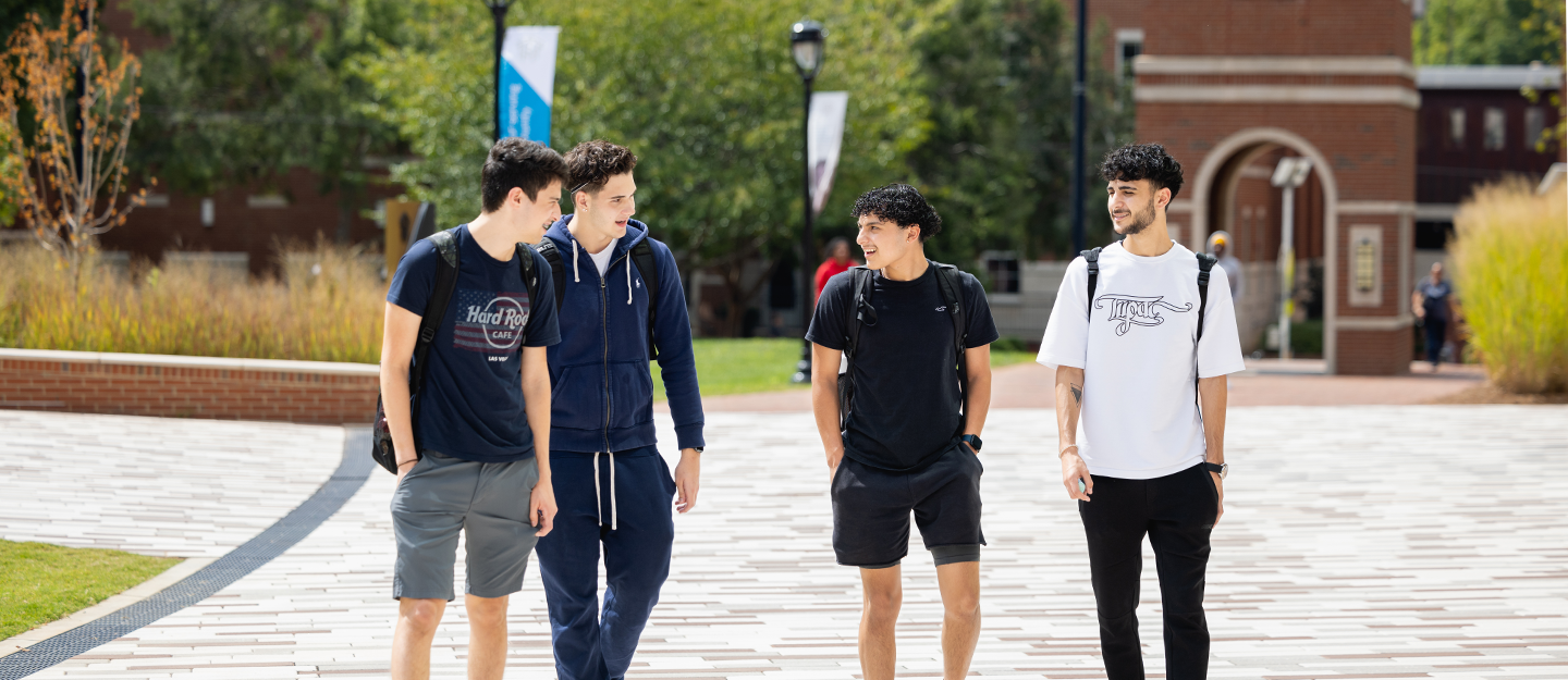 Evergreen Four students in shorts walking and smiling 