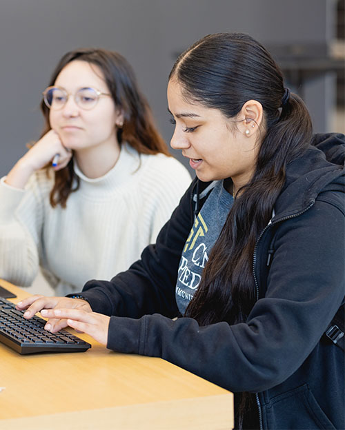 diverse students working together in front of a laptop in the classroom on Central Campus at Central Piedmont Community College