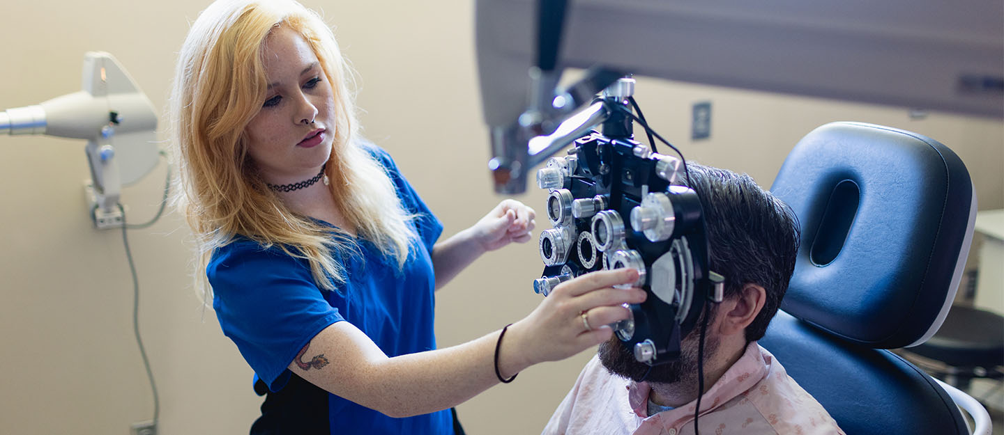 ophthalmic student adjusting eye equipment for patient
