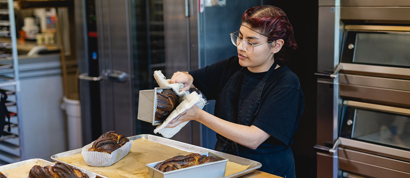 hospitality, culinary, and baking student pulling bread out of the pain