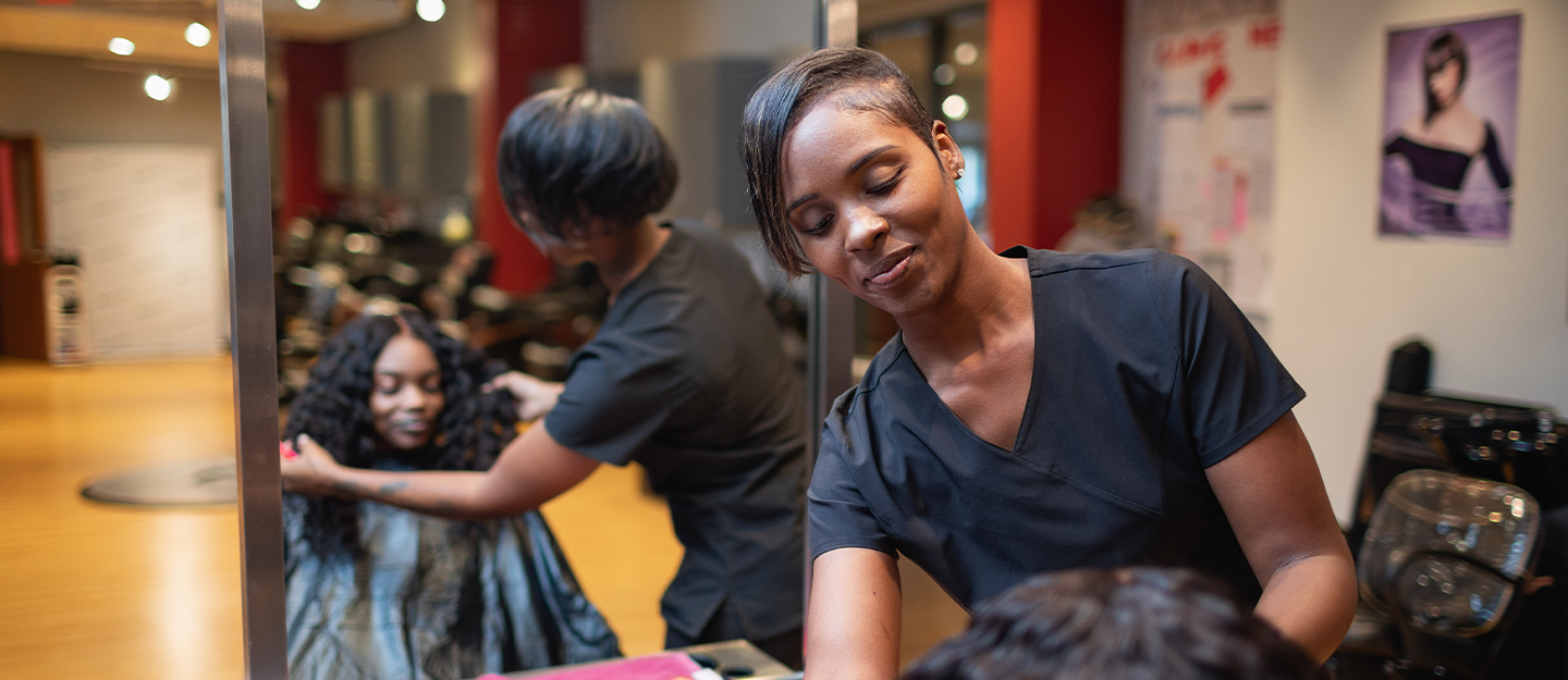 Cosmetology student doing a client's hair 