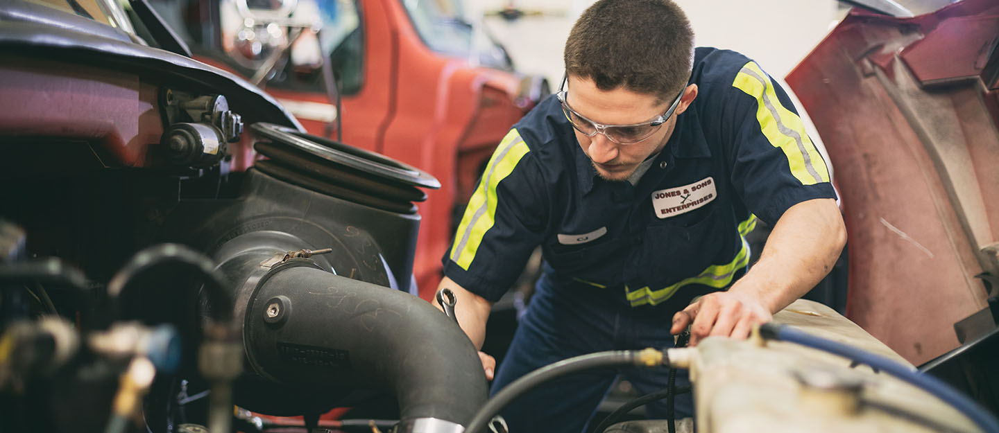 automotive technology student with safety glasses with hands on equipment